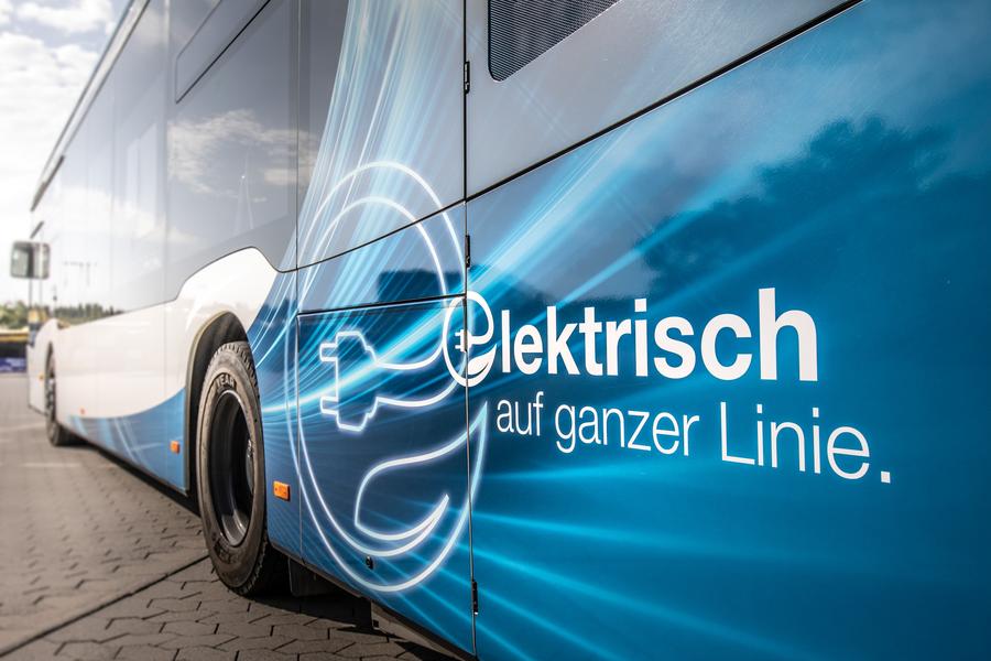 Ein Bus steht auf der Straße, der Fokus liegt auf der Busbeschriftung "Elektrisch auf ganzer Linie".