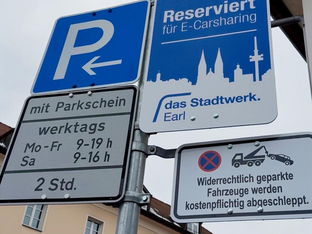 Verkehrsschilder informieren über reservierten Stellplatz für E‑Carsharing sowie kostenpflichtiges Abschleppen bei widerrechtlichem Parken.