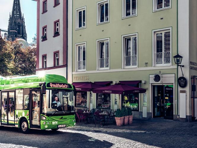 Grüner RVV-Bus, der durch die Gassen der Regensburger Altstadt fährt.